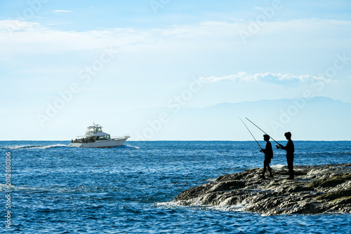 磯で釣りをする人物シルエット｜趣味や休日イメージに使える海景写真