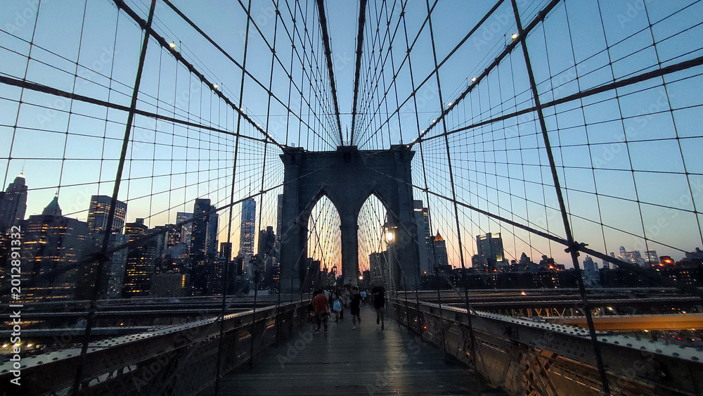 Fototapeta premium Twilight over Manhattan: The Brooklyn Bridge Suspension Cables and Lower Manhattan Skyline at Dusk
