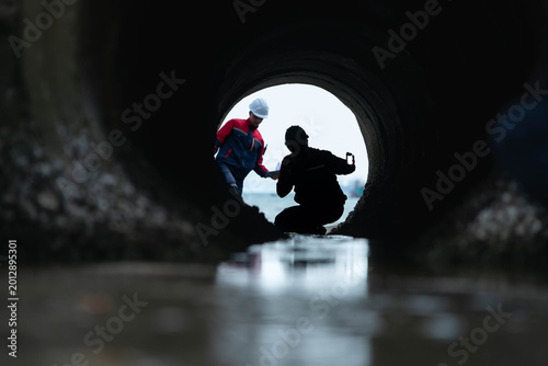 Obraz na płótnie Industrial inspector monitoring wastewater drainage tunnel