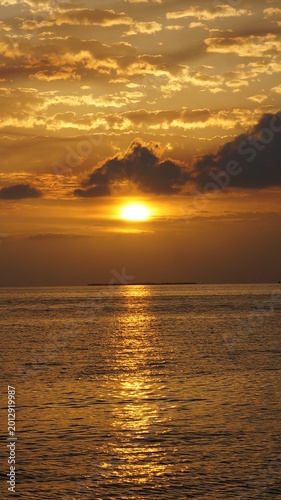 Golden Ocean Sunset With Dramatic Clouds And Water Reflection In Key West Florida USA