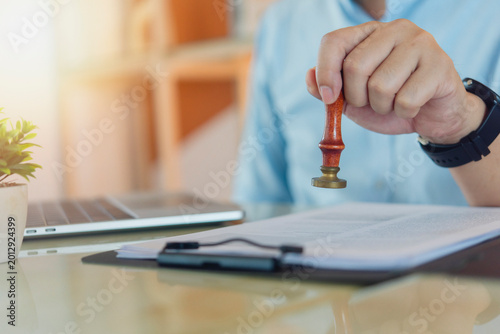 Fotografie Manager hand stamping approval form document office workspace