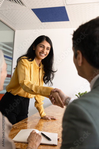 Indian applicant shaking hands with recruiter during office meeting, confirming successful job interview outcome. Hiring process, headhunting agreement, career opportunity, professional onboarding