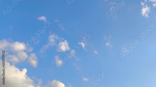 Curious orange clouds moving in the blue sky at sunset