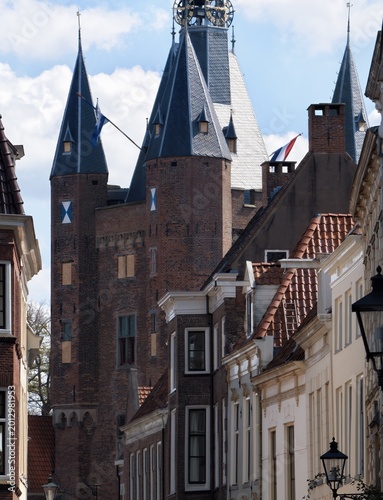 Obraz na plátně Ancient brick gatehouse tower rising above traditional residential homes in a hi