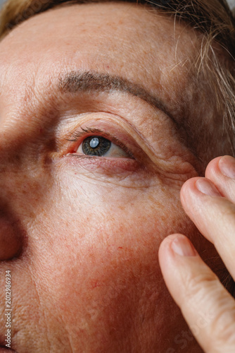 Schilderij op canvas Detailed closeup of mature eye area with authentic skin texture and wrinkles