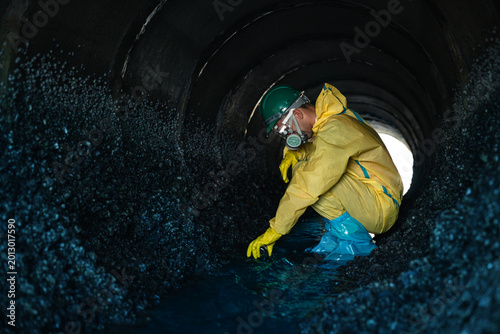Tableau sur toile Environmental Workers Walking Inside Polluted Wastewater Tunnel During Industria