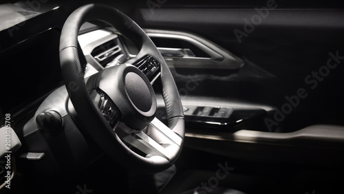 EV Car steering wheel. Modern car interior with luxury steering wheel dashboard and digital monitor controls. Steering wheel and automotive cabin. Car technology comfort and premium design in EV car.