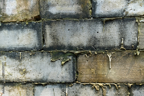 Photos Texture of a weathered concrete block wall with dripping mortar