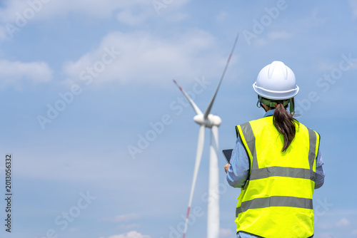 Female Engineer Inspecting Wind Turbine Power Generation Facility