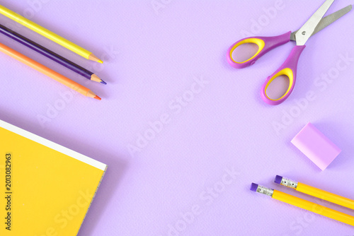 a flat lay of School Supplies on Purple Background copy space
