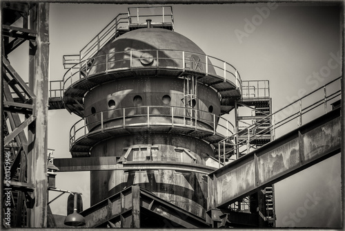 Black and white photograph of an old metal building in a metalworking factory.