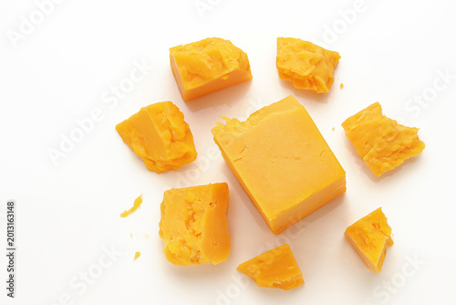 Broken Chunks of Orange Cheddar Cheese on white background