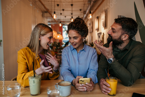 Canvas Print Friends socialising and talking at a coffee shop