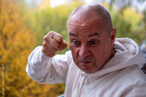 Bild auf Leinwand Angry older man with furrowed brow, intense gaze, and pursed lips