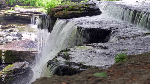 A beautiful flowing water formation under a canopy of trees called Blue Holes Falls shows the surreal, peaceful atmosphere of Old Stone Fort State Park in Tennessee.
