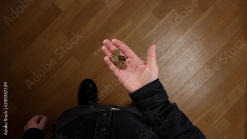 фотографія Person holding a small amount of scattered metal coins in an open palm, depictin