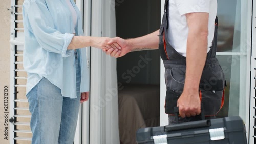 Handyman arrives at client home with toolbox for repair service and shakes hands with homeowner. Professional maintenance, customer care, and trusted service visit concept.