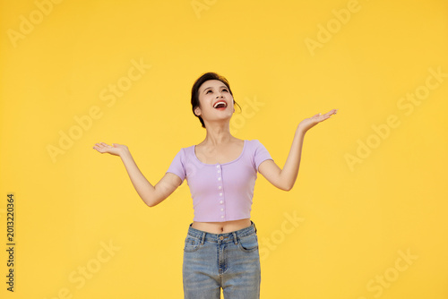 Cuadro en lienzo Cheerful Young Woman With Open Hands on Yellow Background