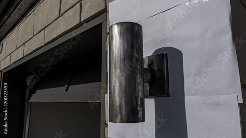 Cuadro en lienzo Outdoor wall light fixture mounted on a textured stone wall, with a blank paper