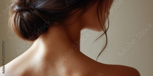 女性の後ろ姿の肩と首筋が写っている。美容やスキンケアのイメージに使える肌のアップ写真。
