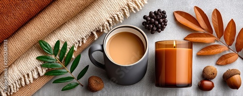 Cozy autumn flat lay with knit blanket, warm coffee mug and lit scented candle