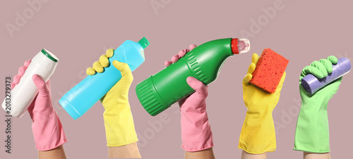 Fotografía Cleaning service workers holding supplies and detergents against dusty pink back