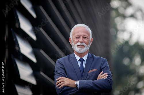Businessman with arms crossed outside
