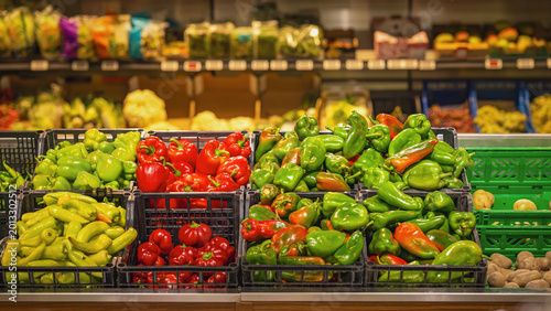 Vegetable farm market. Peppers fill market crates in grocery store, green and red produce on supermarket display for food, retail, cooking, nutrition. Fresh peppers, shopping, agriculture, harvest