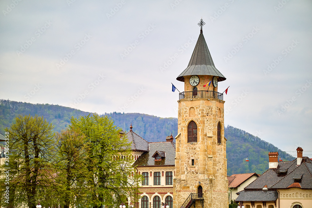 Obraz premium Historic clock tower in charming mountain town with scenic view