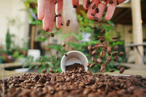 Cinematic Action Shot of Roasted Coffee Beans Falling and Bouncing with Espresso Cup