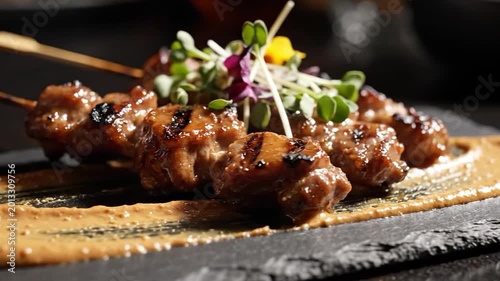 Delicious Chicken Satay Skewers with Peanut Sauce and Garnish on a Dark Plate.