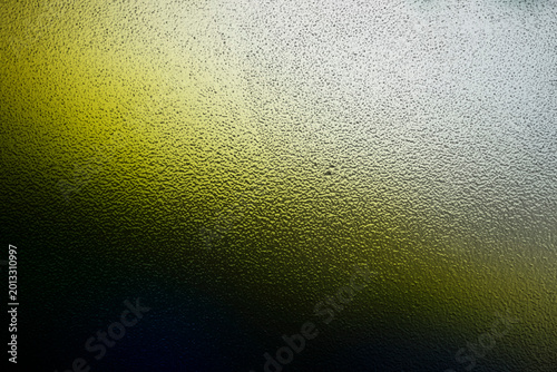 Foto Abstract macro view of bumpy frosted glass illuminated by green and yellow gradi