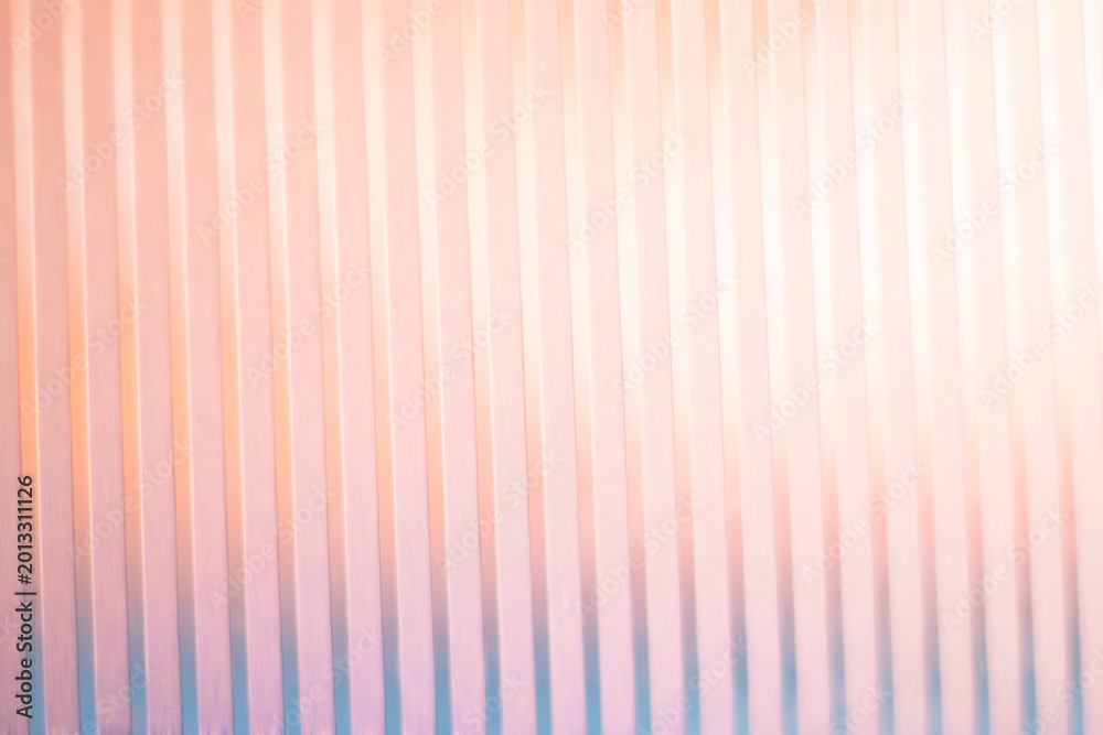 Fototapeta premium Soft peach and pink gradient light on vertical ribbed glass texture