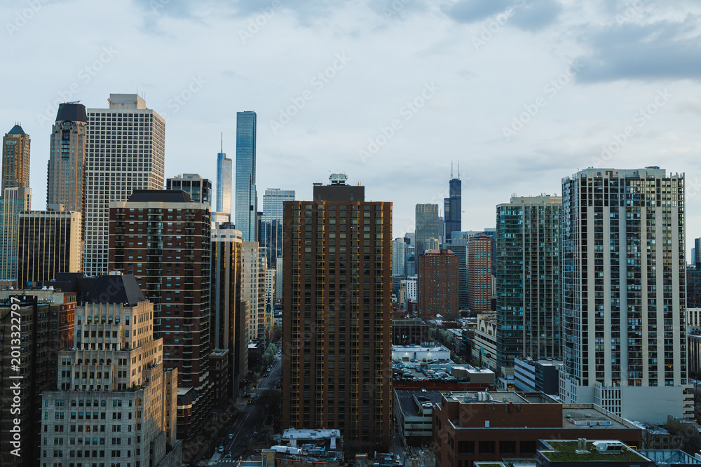 Obraz premium View of Chicago skyline with tall buildings and a cloudy sky during late afternoon