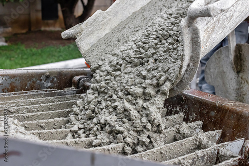 Konstfotografi Wet concrete mixture with gravel unloading into pumping hopper, close up industr