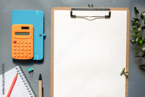 White paper with calculator and pencil on wood background,Office Desk Business concept.
