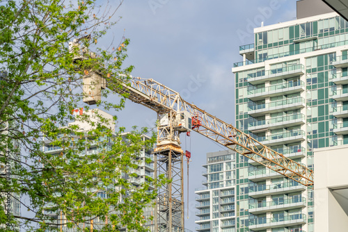 Tower crane among modern residential high rise buildings in urban cityscape