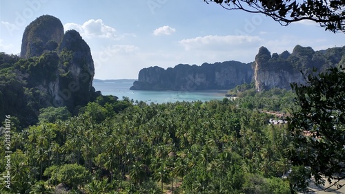 High-angle panoramic view of Railay Beach West in Krabi, Thailand. Tropical coastline with turquoise Andaman Sea, white sand, and lush limestone cliffs.