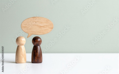 Two wooden figures converse symbolizing communication and dialogue.