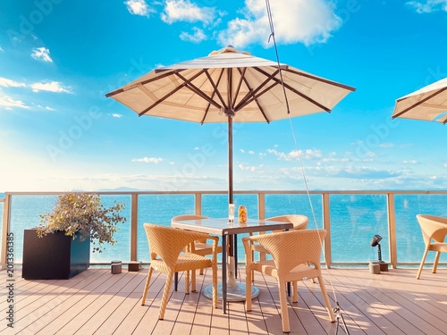 Photography Luxury oceanfront terrace cafe with blue sky and resort atmosphere