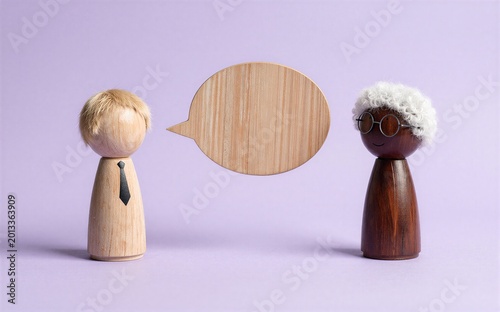 Two wooden figures converse one with a speech bubble between them.