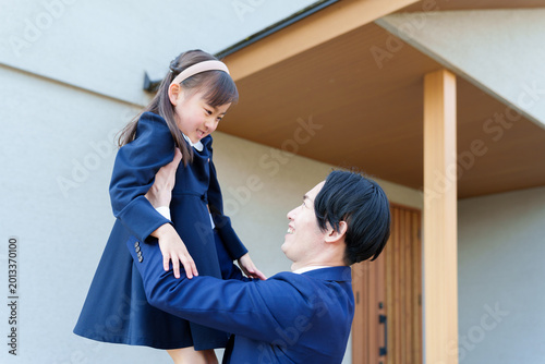 自宅の前で女の子を持ち上げるお父さん