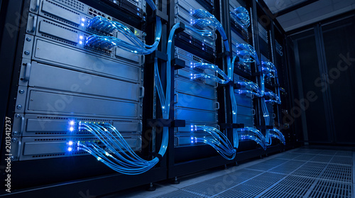 Photos Wide photograph of server racks with blue network cables in a modern data center, highlighting digital infrastructure