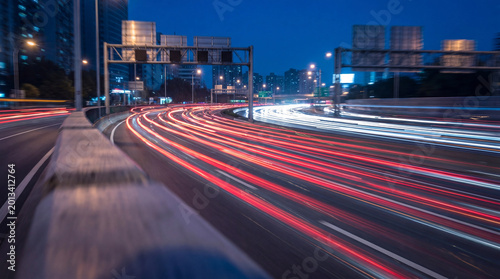 Tableau sur toile Dynamic long exposure photograph of car light trails on a busy city highway at dusk
