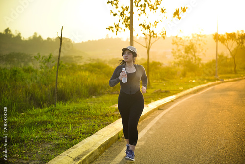 Photos Woman runs along a quiet path at sunrise