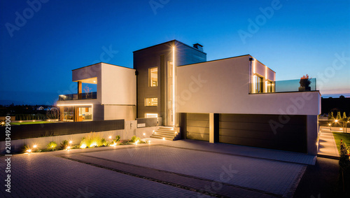 Photos Modern luxury residential house exterior at night with driveway lighting real es