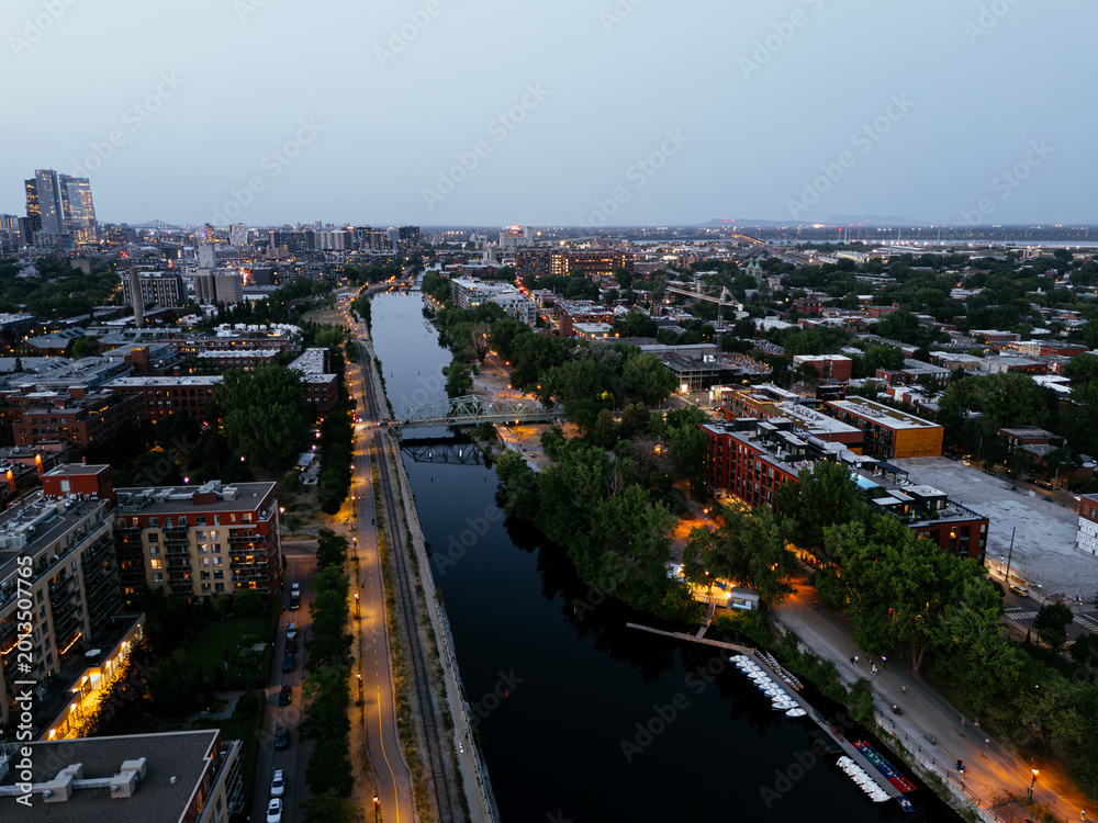 Fototapeta premium Montreal skyline and Lachine Canal at blue hour with illuminated cityscape and urban waterfront, Canada. g.