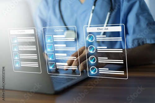 Healthcare professional reviewing digital checklist and patient records on laptop for clinical workflow management and medical data organization