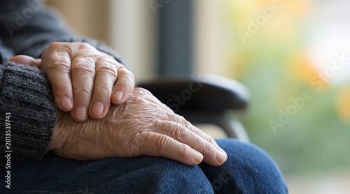 Close up of wrinkled hands of elderly person resting on lap