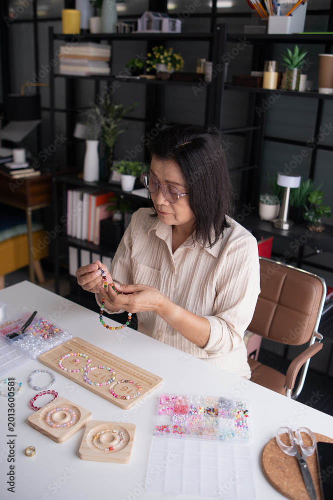 Fototapeta premium Mature asian woman&nbsp;making handmade jewellery accessories handcraft hobby